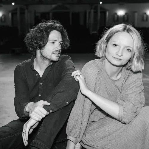 Folk-country duo Sam and Beth Goudie sitting together on a stage